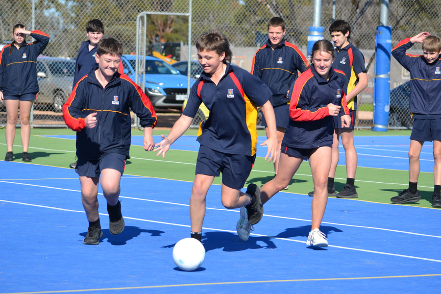 PE > Jack, Cooper and Lily compete for the ball while learning about soccer.