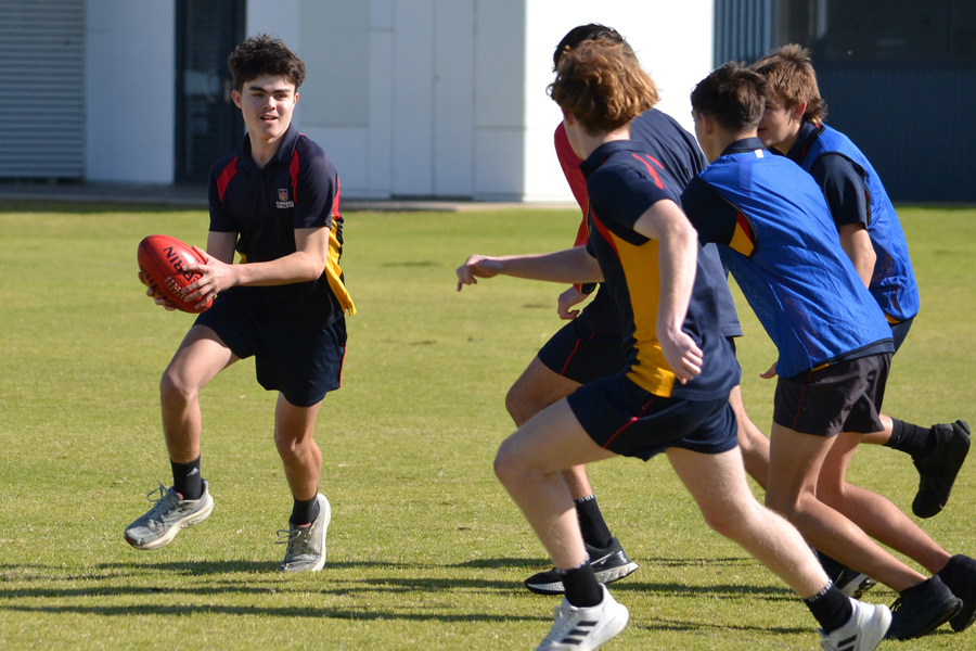 AFL > Bailey takes the ball during a drill for the AFL Intergrated Learning subject in Year 10.