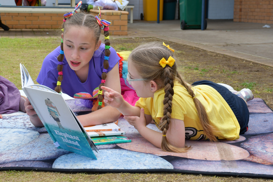 BUDDIES > Anna and Evelyn enjoying a book together.