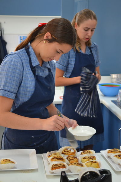 HOME EC > Year 10 students prepared a range of treats for a bake sale last week. Pictured is Maelie glazing cinnamon scrolls for the sale.