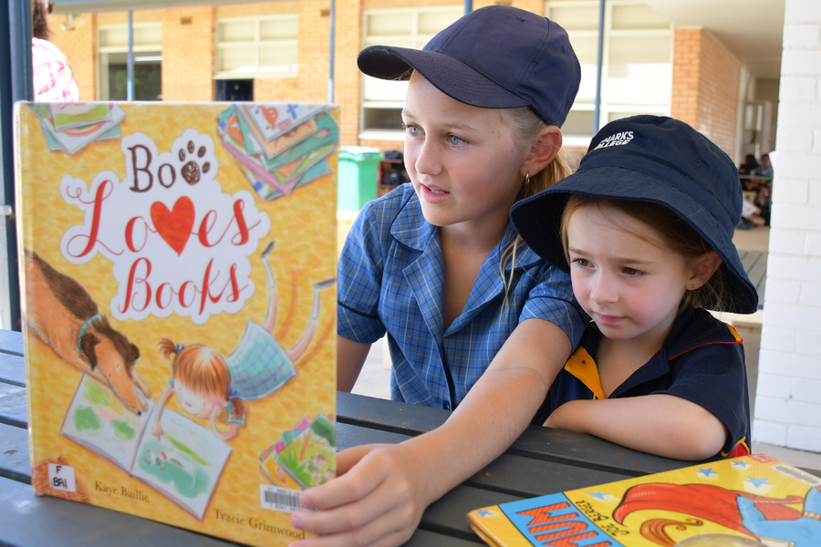 BUDDIES > Year 6 student Millie shares a story with her Reception Buddy Luna.